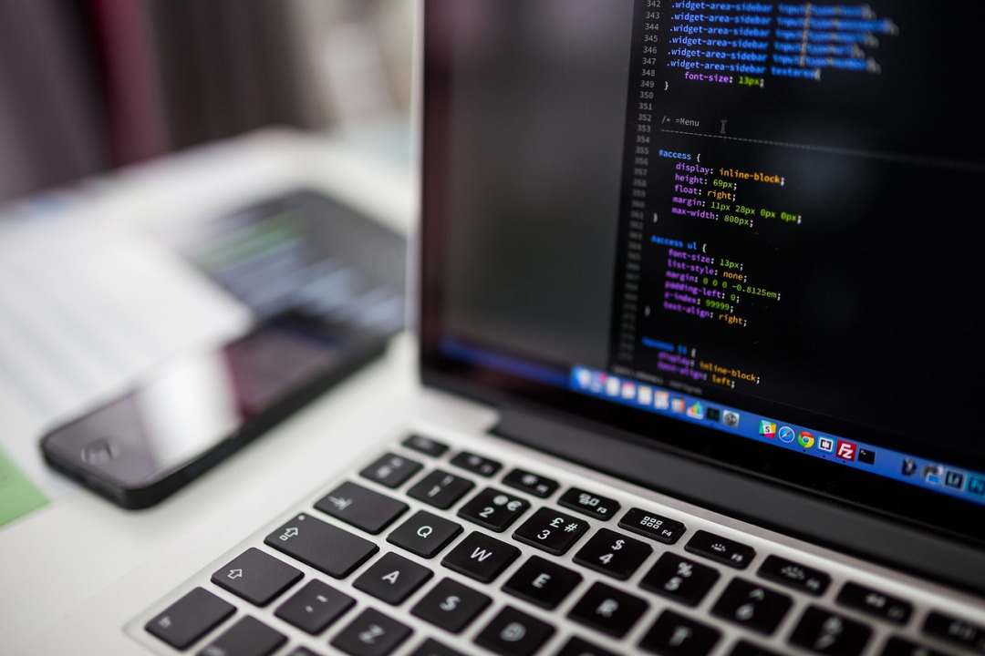 developer coding on laptop in office